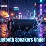 A promotional image shows a black Hoco bluetooth speaker splashing in water on a wet street. The "Gadgeterians" logo is at the top left, and the bottom features glowing text: "Best Bluetooth Speakers Under ৳3,000". The background is a neon-lit city.